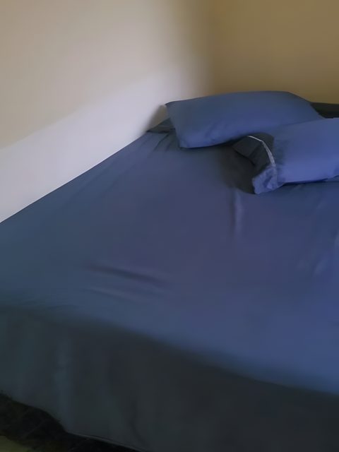 A cama de casal do Quarto 2, com roupa de cama azul.