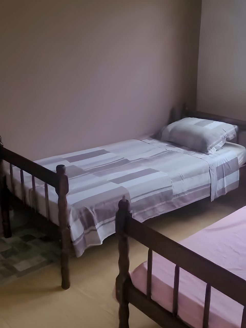 As duas camas de solteiro do Quarto 3, com cabeceira de madeira.